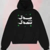 Black Arabic text black hoodie seen from the front featuring "صدق تتصدق" (Believe and you will be believed) in white calligraphy with green stars.