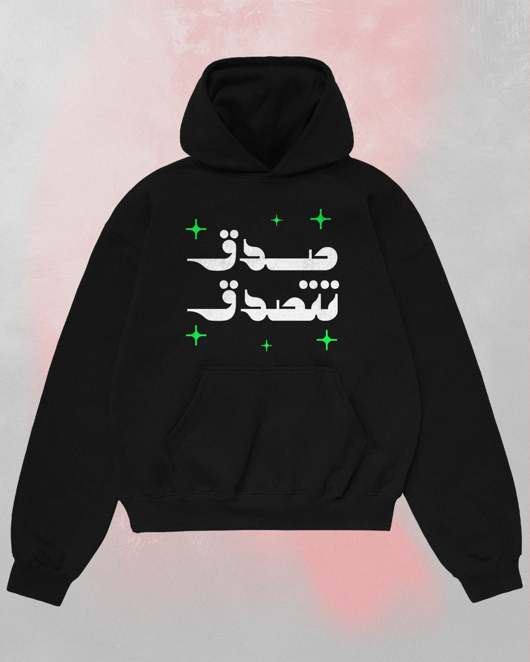 Black Arabic text black hoodie seen from the front featuring "صدق تتصدق" (Believe and you will be believed) in white calligraphy with green stars.