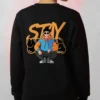 Model wearing a black Stay Urban Cartoon Sweatshirt with a cartoon character sitting in front of graffiti-style “STAY” lettering.
