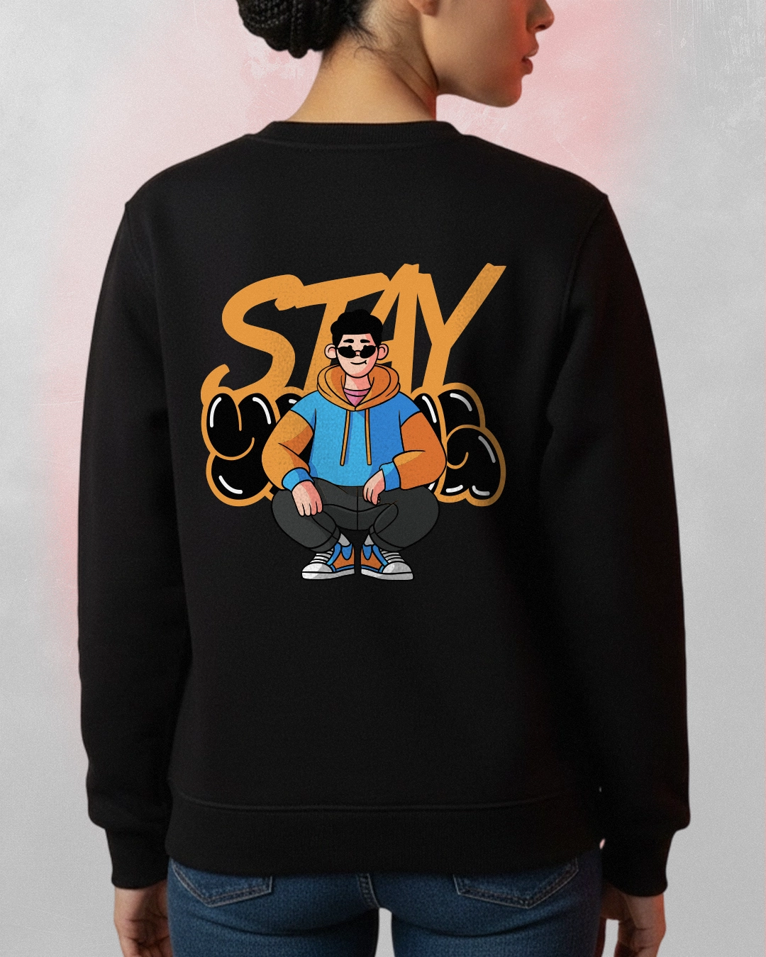 Model wearing a black Stay Urban Cartoon Sweatshirt with a cartoon character sitting in front of graffiti-style “STAY” lettering.